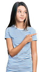 Young brunette girl with long hair pointing with fingers to the side smiling looking to the side...
