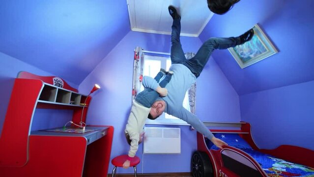 Father with daughter at inverted house and head of boy looking