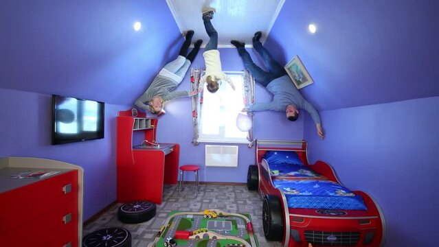 Father, mother, daughter with balloons in room at inverted house