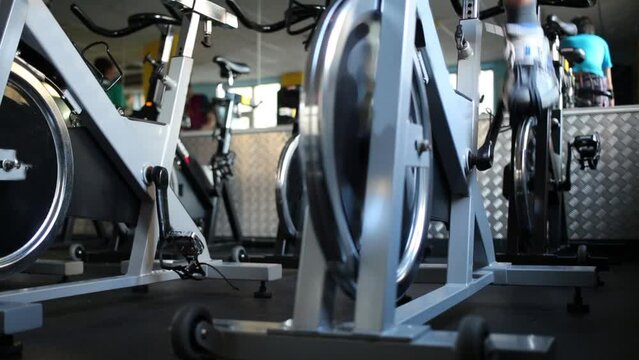 Legs of man who trains on exercise bike in fitness center.