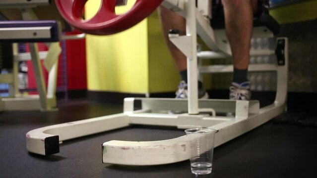 Man does exercise on lifting weight in fitness center.