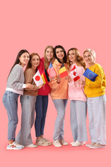 Portrait of beautiful women with different flags on pink background
