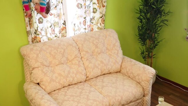 Little girl touches sofa upside down in room of inverted house