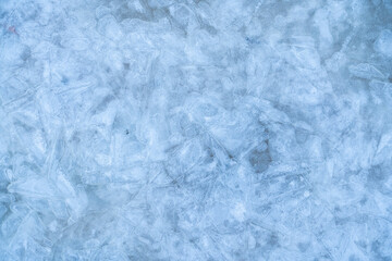 Icy winter background cracked grunge texture. Natural scratched ice on a skating rink as a texture or background for a winter composition, large long painting