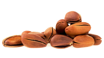 Cedar pine nuts isolated on a white background. Pile of pine nuts in shell.