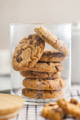 Sweet chocolate cookies in jar on checkered napkin.