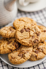 Sweet chocolate cookies on plate on checkered napkin.