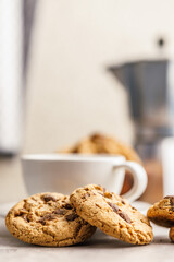 Sweet chocolate cookies and coffee cup on kitchen table.