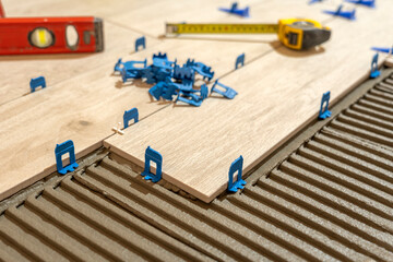 Repair and construction. Laying ceramic tiles using cement on the floor close-up. A man lays slabs on the floor and walls.