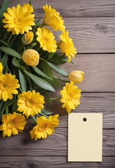 Yellow floral arrangement with paper card for labeling or messaging on rustic wood backdrop.