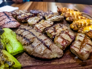 grilled meat and vegetables on a wooden board in the restaurant