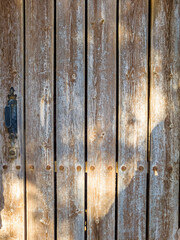 Old wooden door in the stone wall of the house. Abstract background