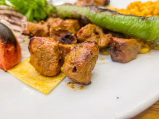 Pork shish kebab with rice and vegetables on a plate
