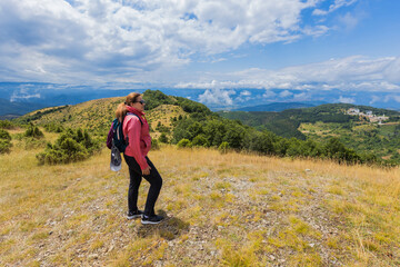 Female hiker enjoy picturesque nature in the summer landscape.