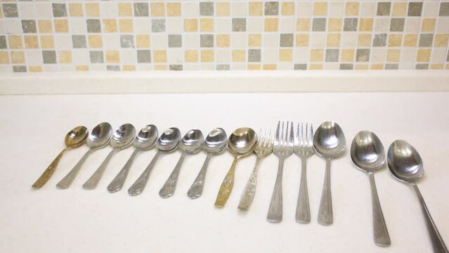 On the table are moved spoons and forks of different size.