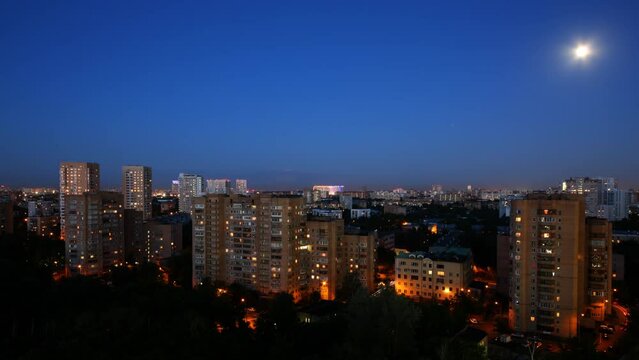 Evening on the town, the moon moves across the sky. Time lapse. 