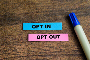 Concept of Opt in and Opt Out write on sticky notes isolated on Wooden Table.