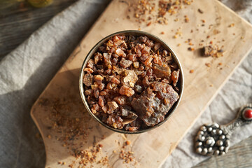 Myrrh resin in a bowl on a table - ingredient for essential oils
