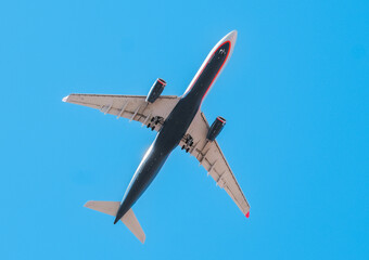 Passenger civil airplane jet flying at flight level high in the sky blue background. Passengers commercial airplane