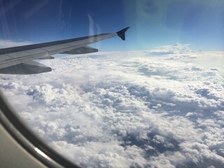 Fototapeta na wymiar View from Airplane Window above the Clouds
