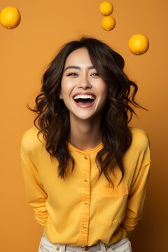 Laughing woman in yellow shirt with lemons