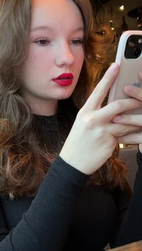 photo glass of latte Ice girl in restaurant making a video for social networks drinking drink beautiful people bright red lipstick black evening dress chic place for dinner. internet wi-fi addiction