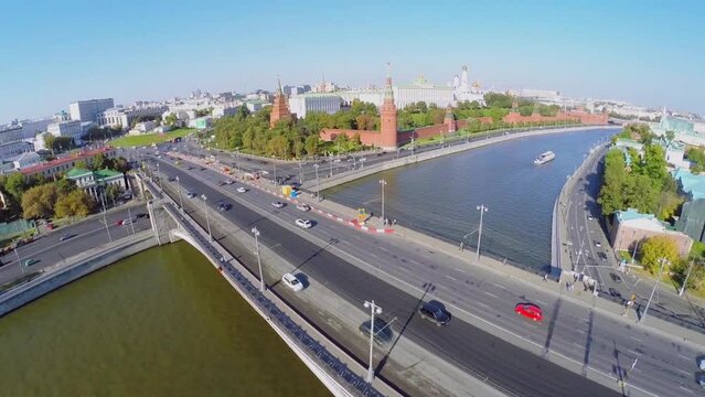 Cars drive by Big Stone bridge and Kremlevskaya quay 