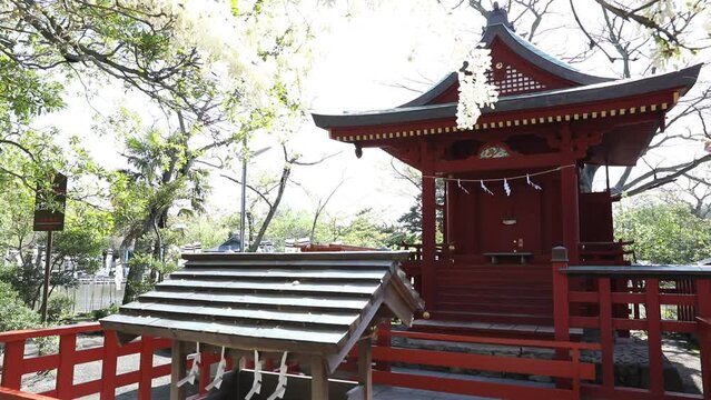 Red architecture of Hata-age Benzaiten Shrine on island on the Minamoto lake inside Tsurugaoka Hachimangu the most important Shinto shrine in Kamakura, Kanagawa Prefecture of Japan. Spring season.