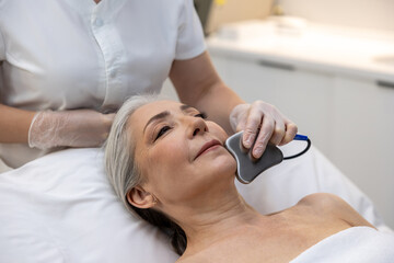 Mature woman having beauty procedure at cosmetological clinic