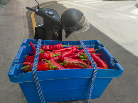 Peasant scooter loaded with tail luggage box full of red guindas