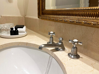 Clean sink and hotel care set in bathroom