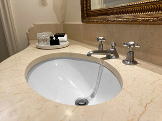 Clean sink and hotel care set in bathroom