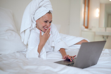 Young woman chatting online and looking contented