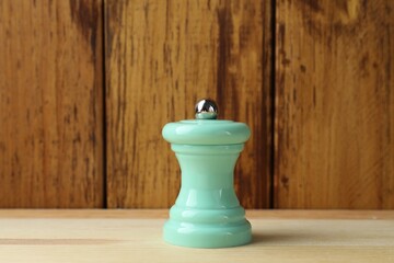 One turquoise shaker on light wooden table