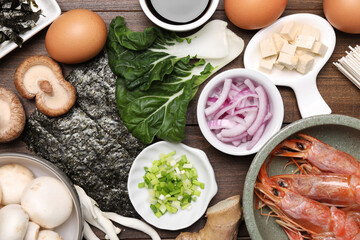 Cooking delicious ramen soup. Different ingredients on wooden table, flat lay