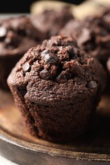 Board with delicious chocolate muffin on table, closeup