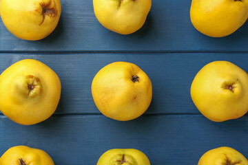 Tasty ripe quinces on blue wooden table, flat lay