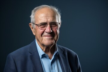 Portrait of a happy senior man with glasses over blue background.