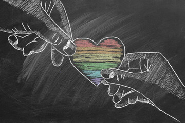 Two hands with a rainbow heart. LGBTQ rights and gender equality concept. Pride month.