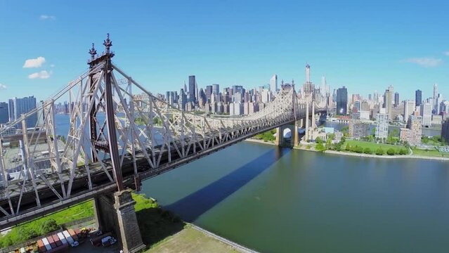 Cars ride by Queensbridge over East River at summer sunny day