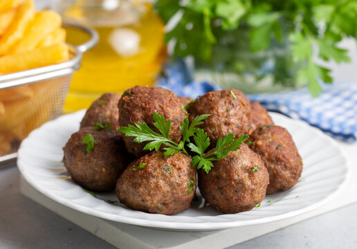 Round shaped balls of dry meatballs and french fries. Turkish name; kuru kofte ve patates