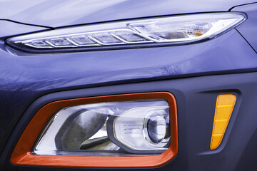 headlight of modern prestigious car closeup. beautiful headlights of a car. dark gray color, red...