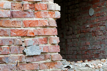 old brick wall. red brick. a hole in a wall, a concept of a ruin, a war or natural disaster. for background and text. may use to interior design. cracked cement joint. close-up, space for text