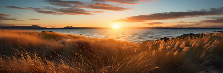 Fototapeten Dünen im Sonnenuntergang am Meer, wunderschöne Natur für einen Urlaub am Strand, Goldene Stunde © GreenOptix