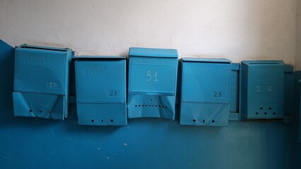 blue mail boxes with dents in former soviet union building