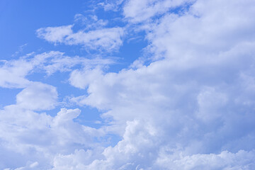 Bodies of cumulus clear white clouds in bright blue sky background.