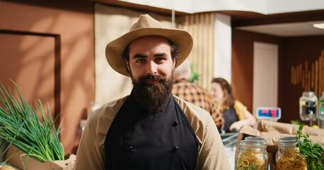 Portrait of smiling vendor adding pantry staples on sustainable zero waste supermarket shelves....