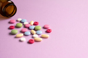 Pills and pill bottles on lilac background. Top view. Flat lay. Copy space. Medicine concept