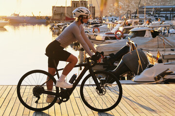 Fit woman cyclist is donned in a complete cycling kit,riding an e-bicycle against the backdrop of a...