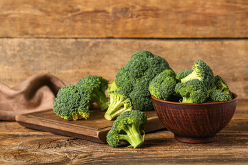 Board and bowl with fresh green broccoli on wooden background